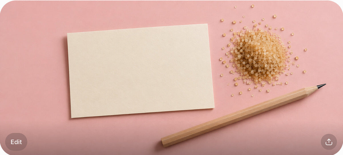 A blank cream notecard, pencil, and sugar pile on a blush surface