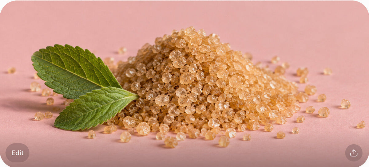 Turbinado sugar mound with two stevia leaves on a blush surface