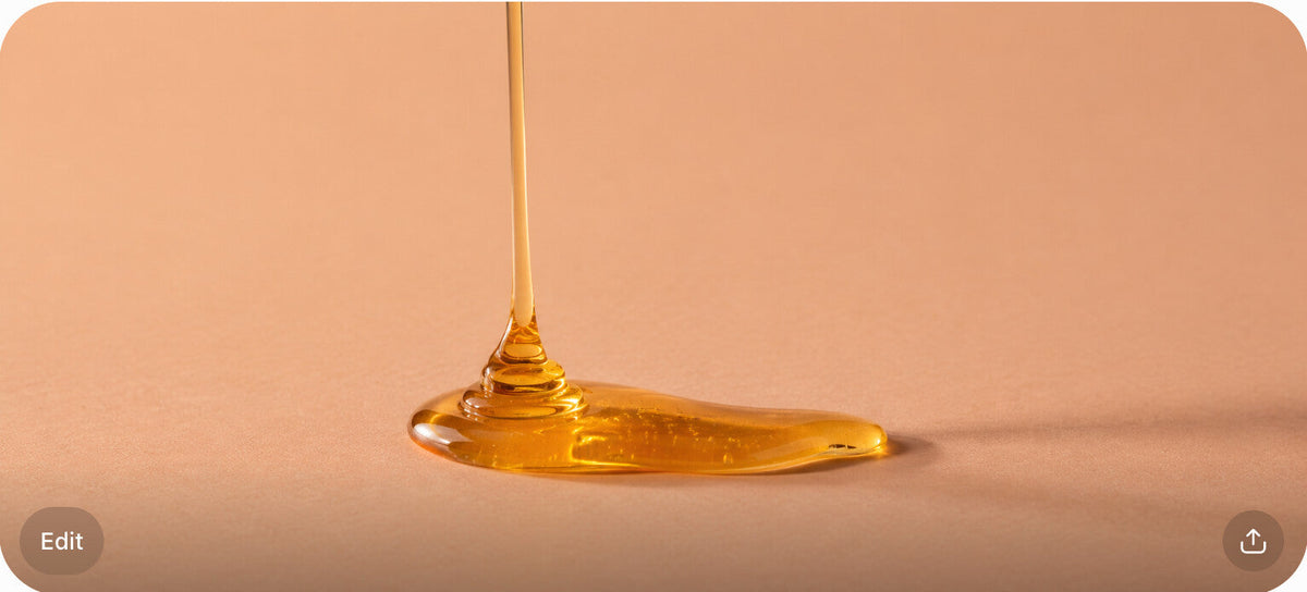 A drizzle of golden syrup in macro detail on a peach surface