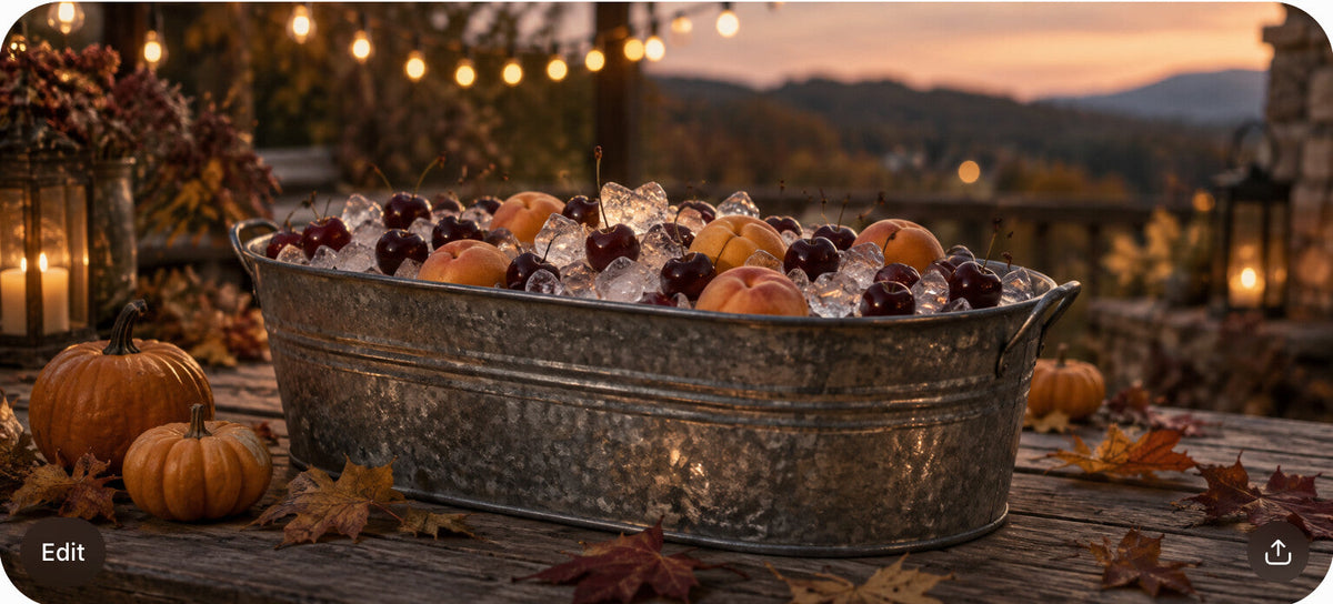 A galvanized ice tub with fruit at dusk, surrounded by pumpkins, autumn leaves, and warm string lights