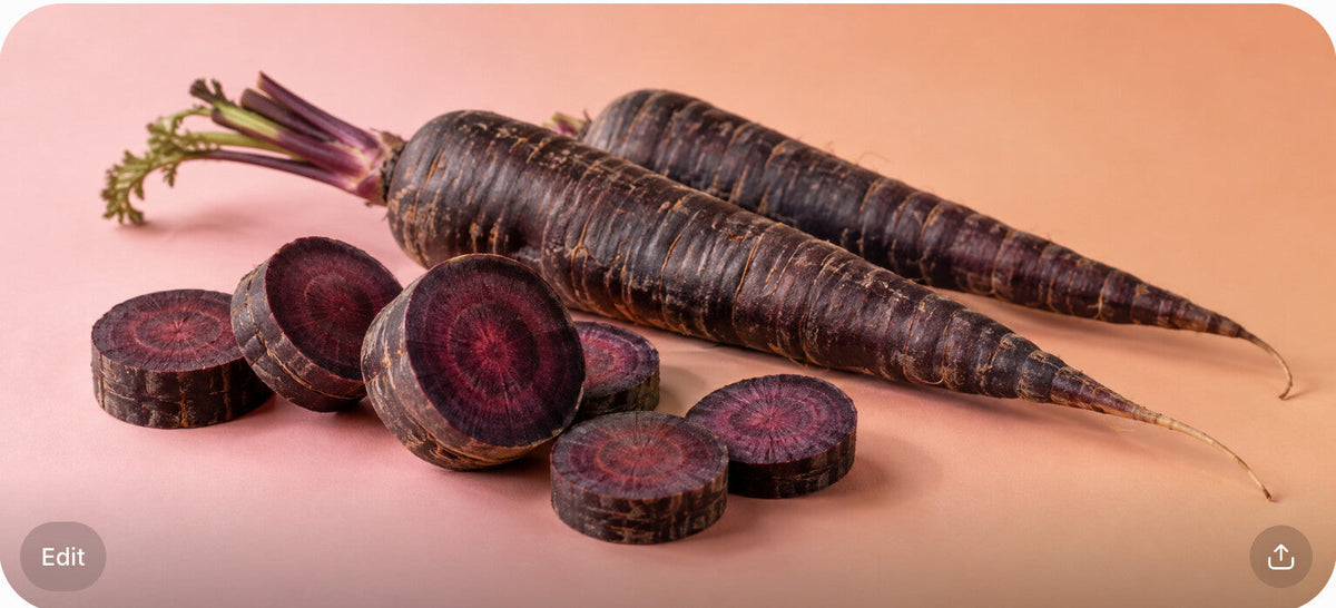 Sliced black carrots revealing deep purple-black flesh next to whole carrots