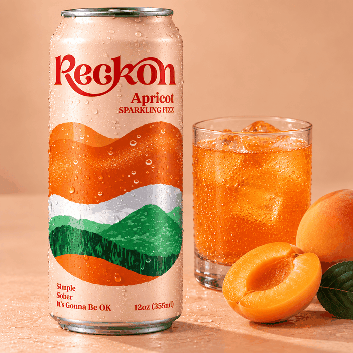 Reckon Apricot can beside a poured glass over ice with fresh apricots